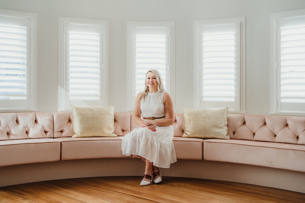 Smiling House Designer sitting on pink sofa